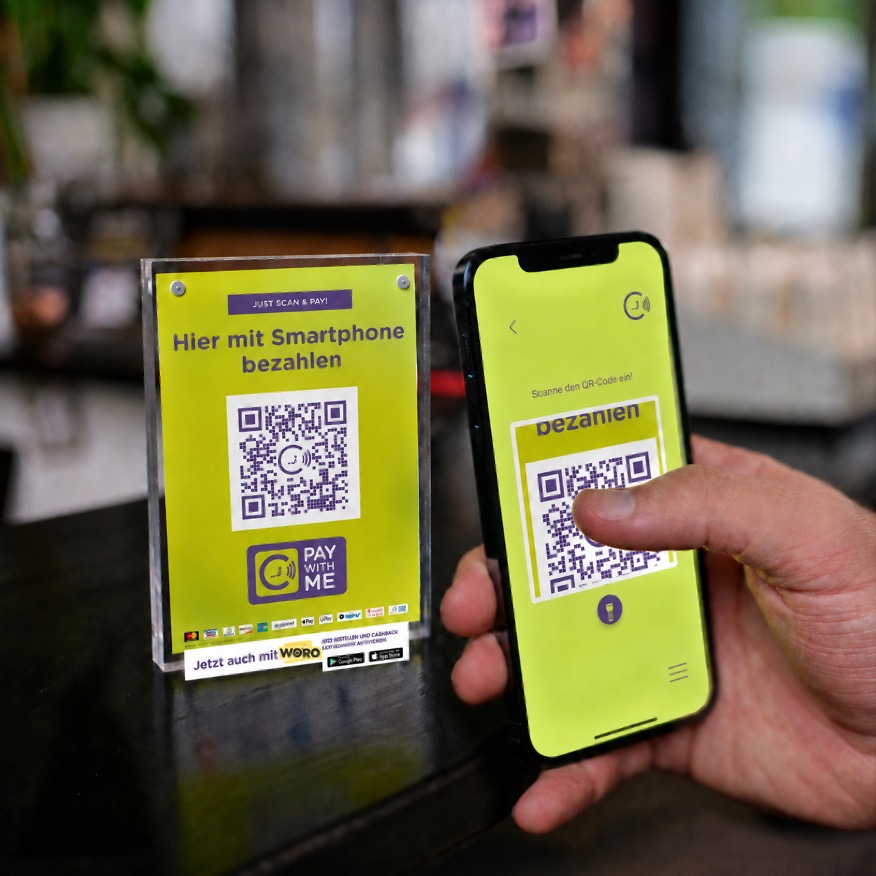 Pay with ME QR-Code wird mit einem Smartphone gescannt.